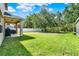 Expansive backyard with lush green grass, mature trees, privacy fence and a covered patio ideal for outdoor living at 8448 Greenbank Blvd, Windermere, FL 34786