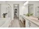 Bright bathroom features double sinks, walk-in shower, soaking tub, and a spacious walk-in closet with custom shelving at 8448 Greenbank Blvd, Windermere, FL 34786