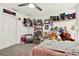 This bedroom boasts a ceiling fan, shelves displaying unique decor, and carpeted floors for comfort at 8448 Greenbank Blvd, Windermere, FL 34786