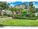 Charming two-story home with landscaped front yard, palm trees, and manicured hedges at 8448 Greenbank Blvd, Windermere, FL 34786