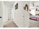 Hallway leading to a carpeted bedroom that features bright walls and an appealing ceiling fan at 8448 Greenbank Blvd, Windermere, FL 34786