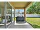 Covered patio featuring an outdoor grill and ample space for entertaining at 8448 Greenbank Blvd, Windermere, FL 34786