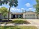 Charming single-story home with well-manicured lawn, palm trees, and two-car garage at 8484 Sandberry Blvd, Orlando, FL 32819