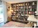 Cozy living room with a large bookshelf, dark floors, an area rug, and sliding doors that open to a patio at 8484 Sandberry Blvd, Orlando, FL 32819