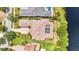 An aerial view highlights the home's tile roof, screened pool, and well-manicured lawn at 8581 Lake Nona Shore Dr, Orlando, FL 32827