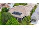 Aerial view showcases the beautiful house, including pool, tile roof, and lush landscaping at 8581 Lake Nona Shore Dr, Orlando, FL 32827