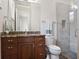 Cozy bathroom with wood cabinets, granite countertops, and a walk-in shower at 8581 Lake Nona Shore Dr, Orlando, FL 32827