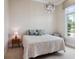 Cozy bedroom with a chandelier above a comfortable bed, creating a peaceful retreat at 8581 Lake Nona Shore Dr, Orlando, FL 32827