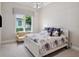 Bright bedroom featuring a floral patterned bed, soft natural light, and a cozy loveseat at 8581 Lake Nona Shore Dr, Orlando, FL 32827