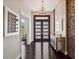 Elegant entryway featuring dark wood floors, a stone accent wall, and decorative lighting at 8581 Lake Nona Shore Dr, Orlando, FL 32827