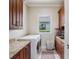 Functional laundry room with ample cabinet space, granite countertops, and modern washer and dryer at 8581 Lake Nona Shore Dr, Orlando, FL 32827