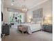 Bright main bedroom with a luxurious king bed, elegant chandelier, and sliding glass doors to the patio at 8581 Lake Nona Shore Dr, Orlando, FL 32827