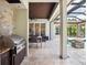 Outdoor kitchen area with a built-in grill, countertop space, and view of the covered patio and pool at 8581 Lake Nona Shore Dr, Orlando, FL 32827