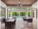 Covered patio with tile flooring, ceiling fan, and dining tables overlooking a sparkling pool and lush landscaping at 8581 Lake Nona Shore Dr, Orlando, FL 32827