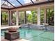Serene pool area featuring water features, a covered lanai, and lush landscaping, creating a private oasis at 8581 Lake Nona Shore Dr, Orlando, FL 32827