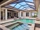 Inviting pool area featuring a spa, covered enclosure, and elegant tile work at 8581 Lake Nona Shore Dr, Orlando, FL 32827