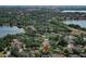 Serene neighborhood aerial shot with mature trees, lake, and city views from above at 8830 Ladrido Ln, Orlando, FL 32836