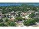 Wide aerial view of a community with tree-lined streets, well-kept homes and lake views in the background at 8830 Ladrido Ln, Orlando, FL 32836