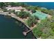 Community aerial view shows tennis courts, a sandy beach, and dock with pristine lake views at 8830 Ladrido Ln, Orlando, FL 32836