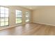 Light-filled bedroom with wood-look flooring and large windows offering ample natural light at 8830 Ladrido Ln, Orlando, FL 32836