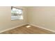 Small bedroom with wood-look flooring and bright window at 8830 Ladrido Ln, Orlando, FL 32836