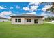 Well-maintained backyard featuring a lush lawn and a seamless transition to indoor spaces through sliding glass doors at 9472 Se 152Nd Pl, Summerfield, FL 34491