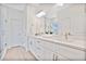 Bright bathroom featuring double sink vanity with quartz countertop, modern fixtures, and a glass-enclosed shower at 9472 Se 152Nd Pl, Summerfield, FL 34491