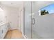 Elegant bathroom with marble-look tile, glass shower, and window offering natural light at 9472 Se 152Nd Pl, Summerfield, FL 34491