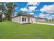 An eye-level view shows the home's well-kept lawn, neutral color palette, manicured landscaping and an attached two-car garage at 9472 Se 152Nd Pl, Summerfield, FL 34491