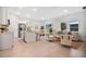 Open-concept layout with island kitchen, dining area, and living space with neutral tones, wood-look floors, and natural light at 9472 Se 152Nd Pl, Summerfield, FL 34491
