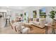 Inviting living space with contemporary furnishings, neutral color palette, wood-look floors, and abundant natural light from large windows at 9472 Se 152Nd Pl, Summerfield, FL 34491