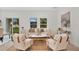 Cozy living room featuring comfortable seating, a modern coffee table, wood-look floors, and large windows with backyard views at 9472 Se 152Nd Pl, Summerfield, FL 34491
