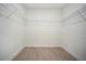 Empty walk-in closet with wire shelving and wood-look flooring, offering ample storage space at 9472 Se 152Nd Pl, Summerfield, FL 34491