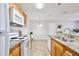 Open kitchen featuring granite countertops, wood cabinets, and a dining area at 956 Salt Pond Pl # 207, Altamonte Springs, FL 32714