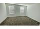 Bright bedroom with neutral carpet, white walls, and lots of natural light from two windows at 11296 Listening Dr, Orlando, FL 32832