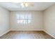 Bedroom with neutral walls, hardwood floors, ceiling fan, and a large window at 121 Primrose Dr, Longwood, FL 32779