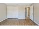 Bright bedroom offers new hardwood floors, closet, and adjacent doorway at 121 Primrose Dr, Longwood, FL 32779