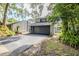 Inviting exterior showcasing a gray two-car garage, lush landscaping, and paved driveway at 121 Primrose Dr, Longwood, FL 32779