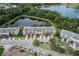 Bird's eye view of well-maintained townhomes nestled near a tranquil pond and featuring manicured lawns at 16064 Old Ash Loop, Orlando, FL 32828