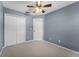Bedroom with carpet, closet, door, and light blue painted walls and ceiling fan at 16064 Old Ash Loop, Orlando, FL 32828