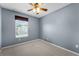 Cozy carpeted bedroom featuring natural light from a window and a ceiling fan at 16064 Old Ash Loop, Orlando, FL 32828