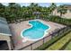 Community pool with ample seating, surrounded by lush greenery and a secure fence for safety at 16064 Old Ash Loop, Orlando, FL 32828