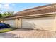 Attached two-car garage with brick paver driveway and lawn at 16064 Old Ash Loop, Orlando, FL 32828