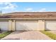 Attached two-car garage with brick paver driveway and manicured lawn at 16064 Old Ash Loop, Orlando, FL 32828