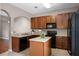 Well-lit kitchen featuring wood cabinets, black appliances, island, and tile flooring at 16064 Old Ash Loop, Orlando, FL 32828