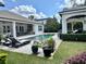 Expansive backyard featuring a pool, outdoor kitchen, cabana, and well-manicured lawn at 1690 Palm Ave, Winter Park, FL 32789