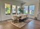 Bright dining room with views from the large windows, wood table and light colored upholstered chairs at 1690 Palm Ave, Winter Park, FL 32789