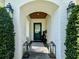 Inviting entryway with a painted brick archway, a teal door, and stylish light fixtures at 1690 Palm Ave, Winter Park, FL 32789