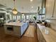 Open concept kitchen features an island, stainless steel appliances, and a view into the living and dining areas at 1690 Palm Ave, Winter Park, FL 32789