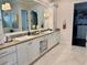 Spacious main bathroom with marble floors, dual sinks, large mirror, and walk-in closet at 1690 Palm Ave, Winter Park, FL 32789